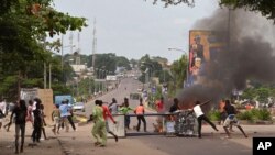 Manifestantes anti-governo nas ruas de Kinshasa esta semana protestando contra nova lei que iria adiar as eleições de 2016