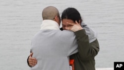 A relative of a passenger aboard the sunken ferry Sewol is consoled by a Buddhist nun, left, as she waits for news on her missing loved one at a port in Jindo, South Korea, Apr. 26, 2014.