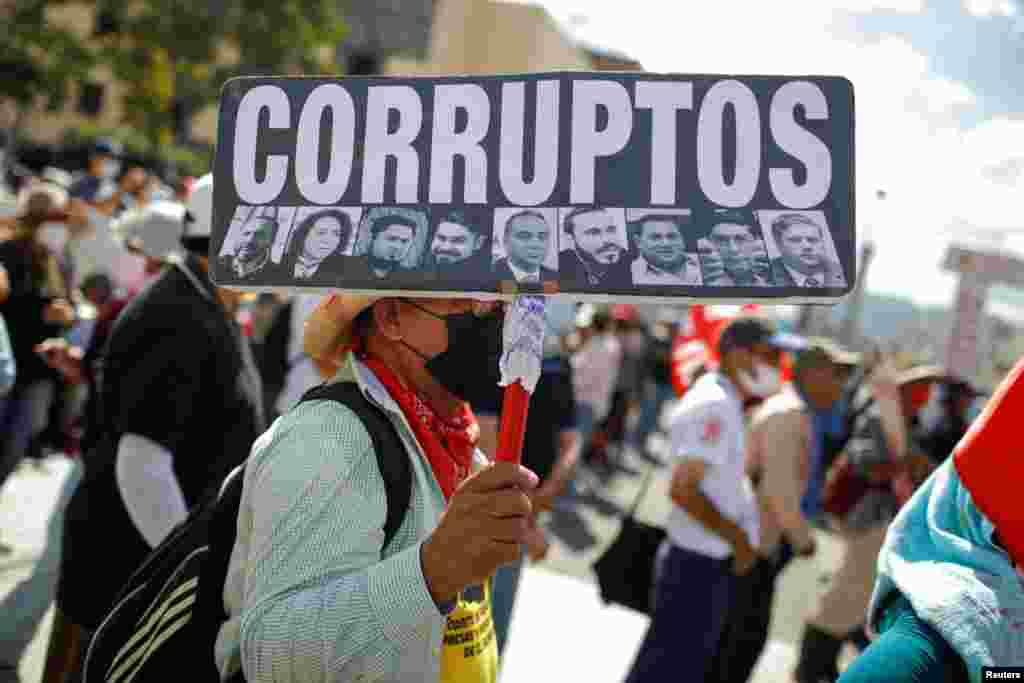 Un hombre sostiene una pancarta que dice &quot;Corruptos&quot; durante una protesta contra las acciones del Gobierno del presidente de El Salvador, Nayib Bukele, como el uso de bitcoin y reformas legales para extender su mandato, en San Salvador, El Salvador, el 12 de diciembre de 2021.