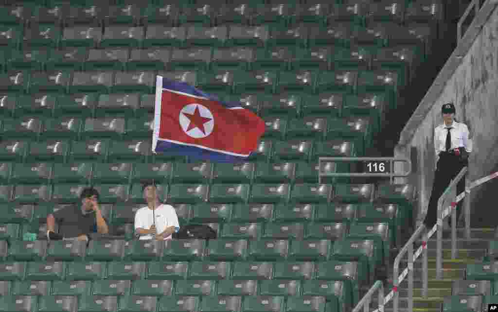 13일 북한과 홍콩의 아시안컵 예선전이 열린 홍콩 경기장에서 북한 대표팀을 응원하는 관중이 인공기를 흔들고 있다.