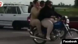 This image taken from video posted on Iranian investigative journalist Masih Alinejad’s Facebook page shows two Iranian women riding a motorcycle. 