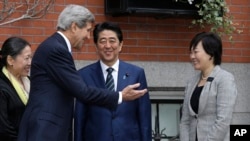 Secretary of State John Kerry, second from left, greets Japanese Prime Minister Shinzo Abe, center, and his wife Akie Abe, right, in front of Kerry's residence in the Beacon Hill neighborhood of Boston, Sunday, April 26, 2015.