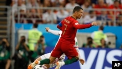 El portugués Cristiano Ronaldo choca con el iraní Alireza Jahanbakhsh durante el partido del grupo B entre Irán y Portugal en la Copa Mundial de fútbol 2018 en el Mordovia Arena en Saransk, Rusia, el lunes 25 de junio de 2018. (AP Photo / Francisco Seco)