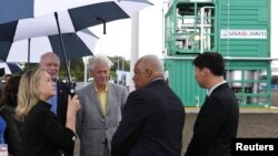 La secretaria de Estado Hillary Clinton y su esposo, el expresidente Bill Clinton, durante la inauguración de la planta eléctrica Caracol, en Haití.