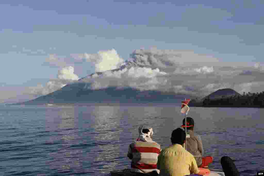 Tiga nelayan melihat ke arah Gunung Gamalama yang menyemburkan abu ke udara saat meletus di Ternate, Pulau Maluku.&nbsp; Indonesia menutup sementara sebuah bandara domestik setelah gunung yang terletak di bagian timur Indonesia itu memuntahkan abu setinggi&nbsp; ratusan meter ke udara. &nbsp;