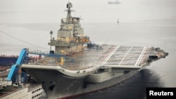 FILE - China's first aircraft carrier, which was renovated from an old aircraft carrier that China bought from Ukraine in 1998, is seen docked at Dalian Port, in Dalian, Liaoning province.