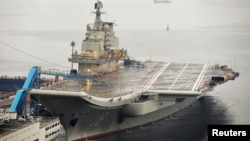 FILE - China's first aircraft carrier, which was renovated from an old aircraft carrier that China bought from Ukraine in 1998, is seen docked at Dalian Port, in Dalian, Liaoning province September 22, 2012. 