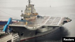 FILE - China's first aircraft carrier, which was renovated from an old aircraft carrier that China bought from Ukraine in 1998, is seen docked at Dalian Port, in Dalian, Liaoning province September 22, 2012. 