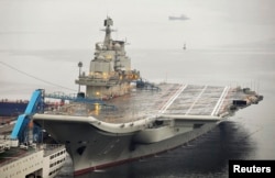 FILE - China's first aircraft carrier, which was renovated from an old aircraft carrier that China bought from Ukraine in 1998, is seen docked at Dalian Port, in Dalian, Liaoning province September 22, 2012.