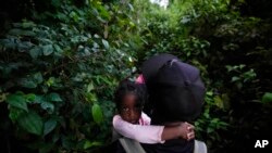 Para migran, termasuk anak anak, melanjutkan perjalanan mereka melintasi jalur di Arcandi, Colombia, untuk menuju wilayah Darien Gap yang merupakan perbatasan antara Panama dan Kolombia, pada 15 September 2021. (Foto: AP/Fernando Vergara)