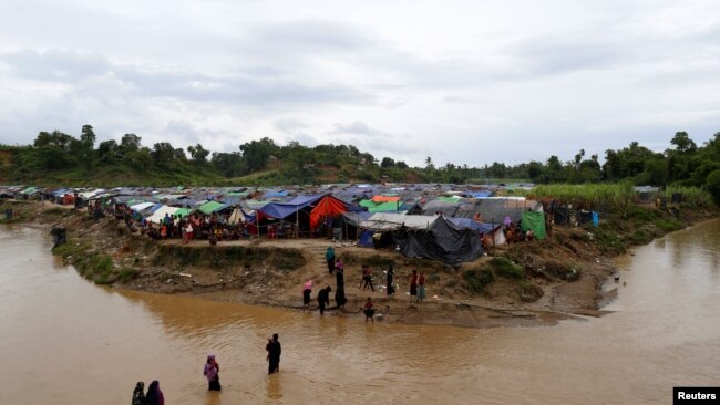 Rohingya refugees cross a stream to reach their temporary shelters at No Man’s Land between the Bangladesh-Myanmar border, at Cox’s Bazar, Bangladesh, Sept. 9, 2017.