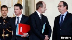 French President Francois Hollande (R) speaks with Justice Minister Jean-Jacques Urvoas (C) as Prime Minister Manuel Valls walks by following the weekly cabinet meeting at the Elysee Palace in Paris, Feb. 3, 2016. 