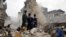 FILE - Rescue workers looking for survivors watch as debris falls from a collapsed building in a densely populated neighborhood in Lagos, Nigeria, Wednesday, July 26, 2017.