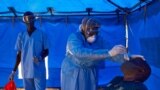  A member of South Sudanese Ministry of Health's Rapid Response Team take a sample from a man who has recently been in contact with a confirmed case of the COVID-19 coronavirus in Juba, South Sudan on April 13, 2020.