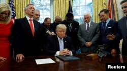 Para pemimpin agama menempatkan tangan mereka di pundak Presiden AS Donald Trump saat ia ikut serta dalam doa untuk orang-orang yang terkena dampak Badai Harvey di Gedung Putih di Washington, 1 September 2017. (REUTERS/Kevin Lamarque)