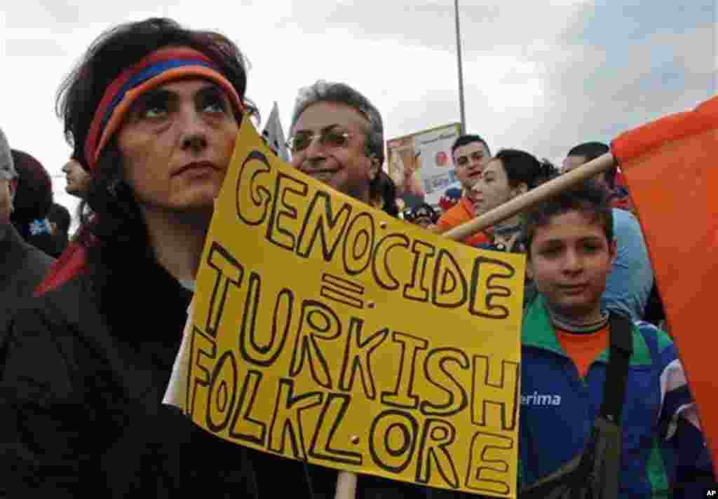 A Lebanese Armenian woman holds a banner during a march to mark the 91st anniversary of massacres in Turkey that began in April 1915 and in which hundreds of thousands of Armenians died, in Antelias, north of Beirut, Lebanon, Monday, April 24, 2006. Armen