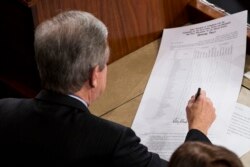 FILE - Sen. Roy Blunt, R-Mo., signs off on an official tally following a joint session of Congress to count Electoral College votes in Washington, Jan. 6, 2017.