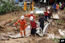 Members of a Myanmar rescue team carry a body at a landslide-hit area in Paung township, Mon State, Myanmar, Aug. 10, 2019.