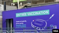 A sign marks the entrance of the Stade de France vaccination center in Saint Denis. (Lisa Bryant/VOA)