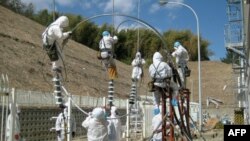 Các nhân viên đang sửa đường dây điện tại nhà máy điện hạt nhân Fukushima Daiichi ở Tomioka, ngày 24 tháng 3, 2011