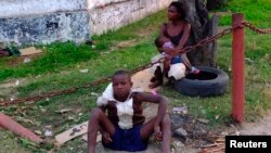 A homeless child repairs a shoe along a street in the Democratic Republic of Congo in Kinshasa on June 16, 2013. Youth poverty and unemployment are fueling criminality in Congo's teeming capital.