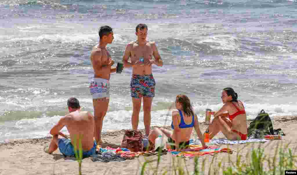 Bañistas disfrutan la playa bajo un cielo soleado antes de la llegada del huracán Dorian a Palm Beach, Florida, EE.UU., el 31 de agosto de 2019. REUTERS / Joe Skipper.