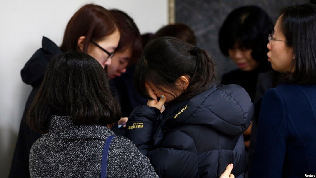 Friends of victims who were killed when a resort building collapsed, react after they paid their tribute outside a group memorial altar in Gyeongju, about 375 km (235 miles) southeast of Seoul February 18, 2014. Ten people attending a welcoming party for