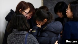 Friends of victims who were killed when a resort building collapsed, react after they paid their tribute outside a group memorial altar in Gyeongju, about 375 km (235 miles) southeast of Seoul February 18, 2014. Ten people attending a welcoming party for