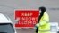 A NHS worker passes a COVID-19 test kit to a driver at a mobile test center, amid the coronavirus outbreak, in Broxbourne, Hertfordshire, Britain, Feb. 2, 2021. 