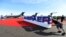 FILE - Workers set up at an Embraer display area prior to the opening of the National Business Aviation Association (NBAA) exhibition in Las Vegas, Nevada, Oct. 21, 2019.