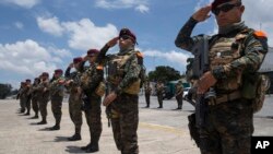 Soldados saludan los restos de tres camaradas que fueron asesinados en enfrentamientos con presuntos narcotraficantes a su arribo a una base de la Fuerza Aérea en Ciudad de Guatemala el jueves, 5 de septiembre, de 2019.