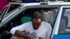 FILE - A taxi driver checks his smartphone as he waits for his customers in Addis Ababa, Ethiopia, Nov. 12, 2019.