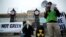 FILE: A Green activist, wearing a mask depicting French President Emmanuel Macron, protests a push to include nuclear energy and natural gas in the EU Green taxonomy, in front of the Quai d'Orsay in Paris, France, Dec. 14, 2021.