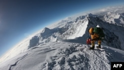 FILE - Mountaineers make their way to the summit of Mount Everest, as they ascend on the south face from Nepal, May 17, 2018.