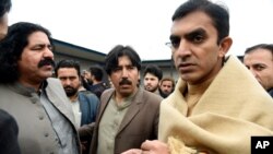 FILE - In this Jan. 27, 2020, photo, leaders of the Pashtun Tahafuz (Protection) Movement or (PTM), Mohsin Dawar, right, and Ali Wazir, left, protest the arrest of their leader in Islamabad, Pakistan.