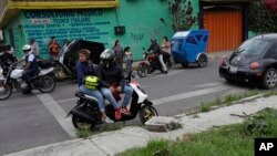 FILE - Residents and motorcycle taxi drivers stop to look at marines blocking the area where a suspected drug gang leader and seven others were killed in a shootout in the Tlahuac district of Mexico City, July 20, 2017. 