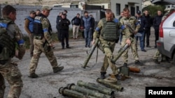 一名警察工兵从刚刚被乌军收复的乌达村返回后在佐洛奇夫镇检查未爆弹药。(2022年9月12日)