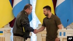 El presidente de Ucrania, Volodymyr Zelenskyy, a la derecha, y el presidente de Guatemala, Alejandro Giammattei, se dan la mano durante una conferencia de prensa después de su reunión en Kiev, Ucrania, el 25 de julio de 2022.