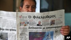 A man reads a Cypriot newspaper with a front page carrying a photo montage about Turkey's actions over Cyprus and international companies exploration for gas in the eastern Mediterranean in capital Nicosia, Cyprus, Feb. 13, 2018. 