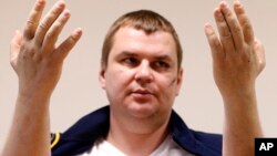 Ukrainian opposition activist Dmytro Bulatov holds up his hands that were pierced with nails, during a press conference in a hospital in Vilnius, Lithuania, Feb. 6, 2014. 