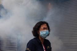 A woman reacts after riot police fired tear gas to disperse protesters taking part in a pro-democracy rally against a proposed new security law in Hong Kong, May 24, 2020.