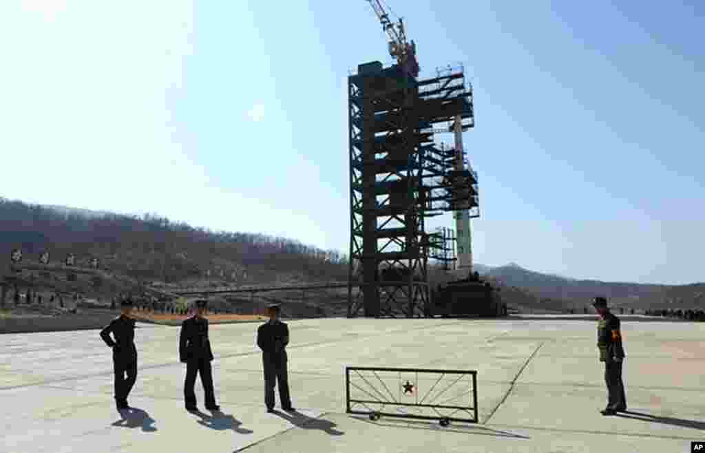 朝鲜士兵守卫在平安北道东仓里航天基地“银河3号”三级火箭的发射台旁