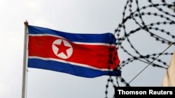 FILE PHOTO: A North Korea flag flutters next to concertina wire at the North Korean embassy in Kuala Lumpur