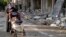 A woman and child along a damaged street in rebel-held city of Homs on January 29, 2014. 