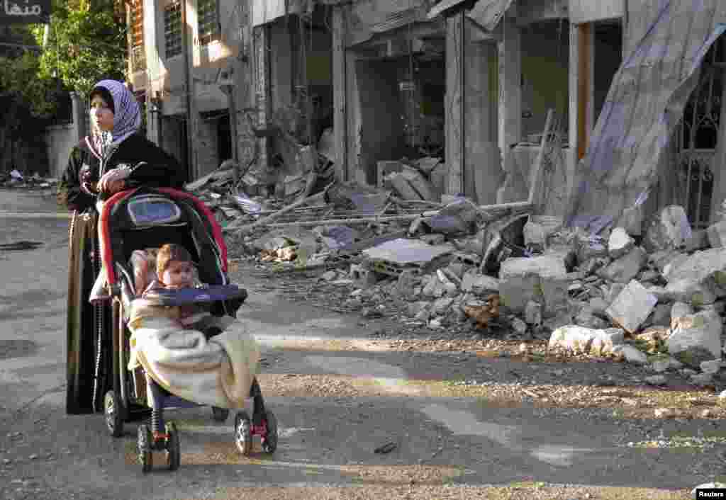 A woman stands along a damaged street in the besieged area of Homs, Syria, Jan. 29, 2014.&nbsp;