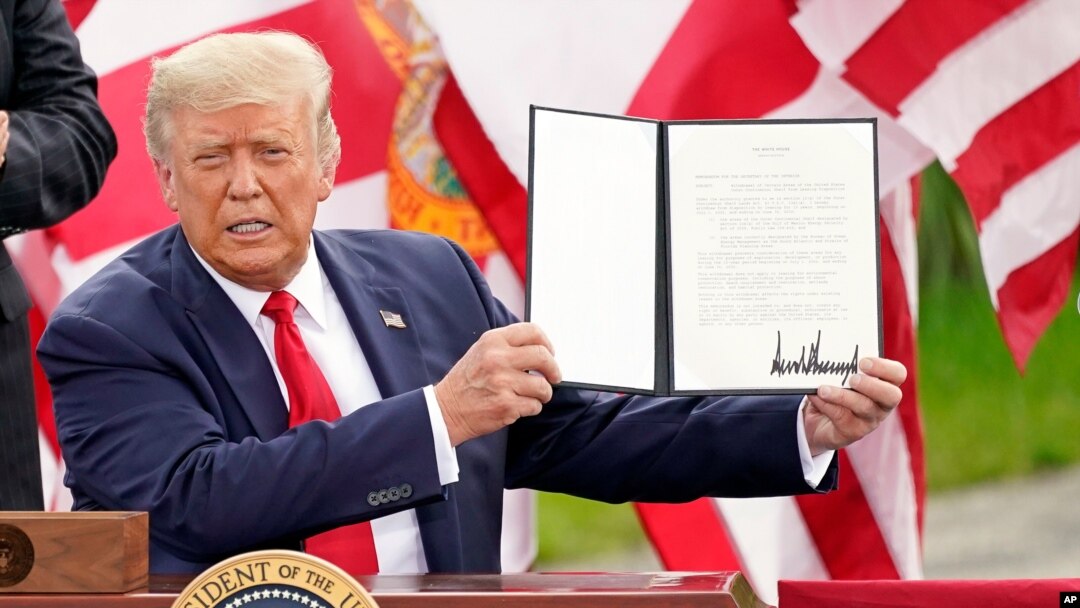 President Donald Trump holds a signed memorandum to expand the offshore drilling moratorium to Florida's Atlantic coast, Georgia and South Carolina after speaking on Sept. 8, 2020, in Jupiter, Fla. 