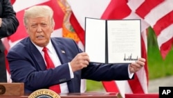 President Donald Trump holds a signed memorandum to expand the offshore drilling moratorium to Florida's Atlantic coast, Georgia and South Carolina after speaking on Sept. 8, 2020, in Jupiter, Fla. 