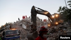 Rescue workers search for survivors at a collapsed building after an earthquake in Izmir