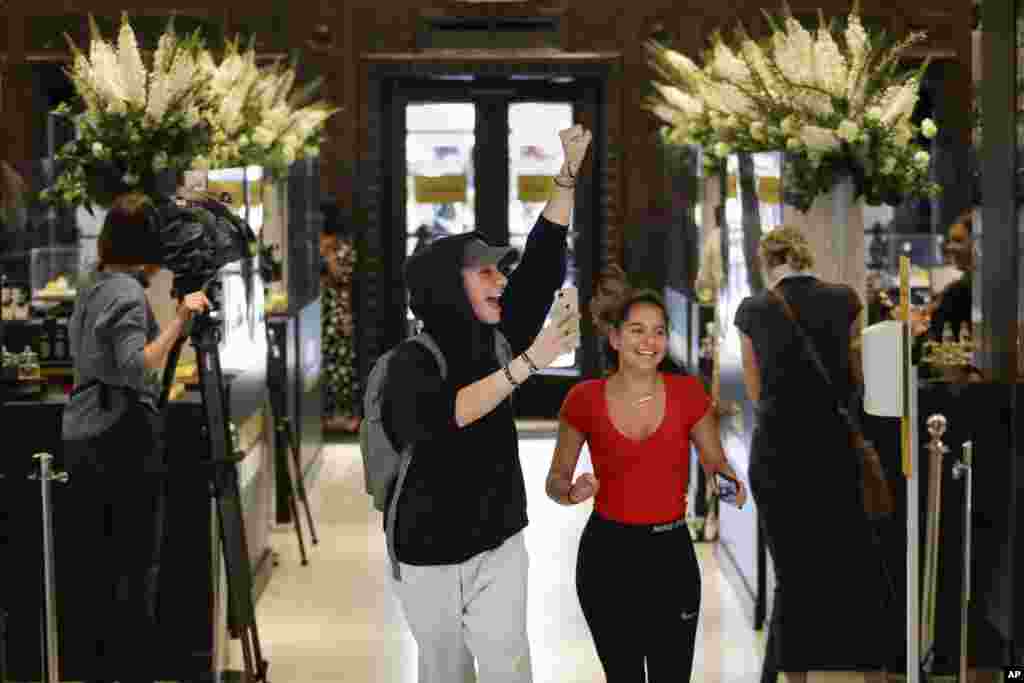 People cheer as they are permitted to enter the Selfridges department store in London. Stores selling clothes, toys and other non-essential goods re-opened amid the COVID-19 outbreak.