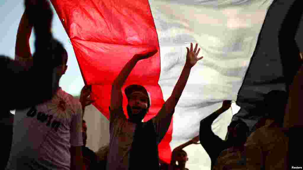 Protesters bear a giant Egyptian flag in Tahrir Square.